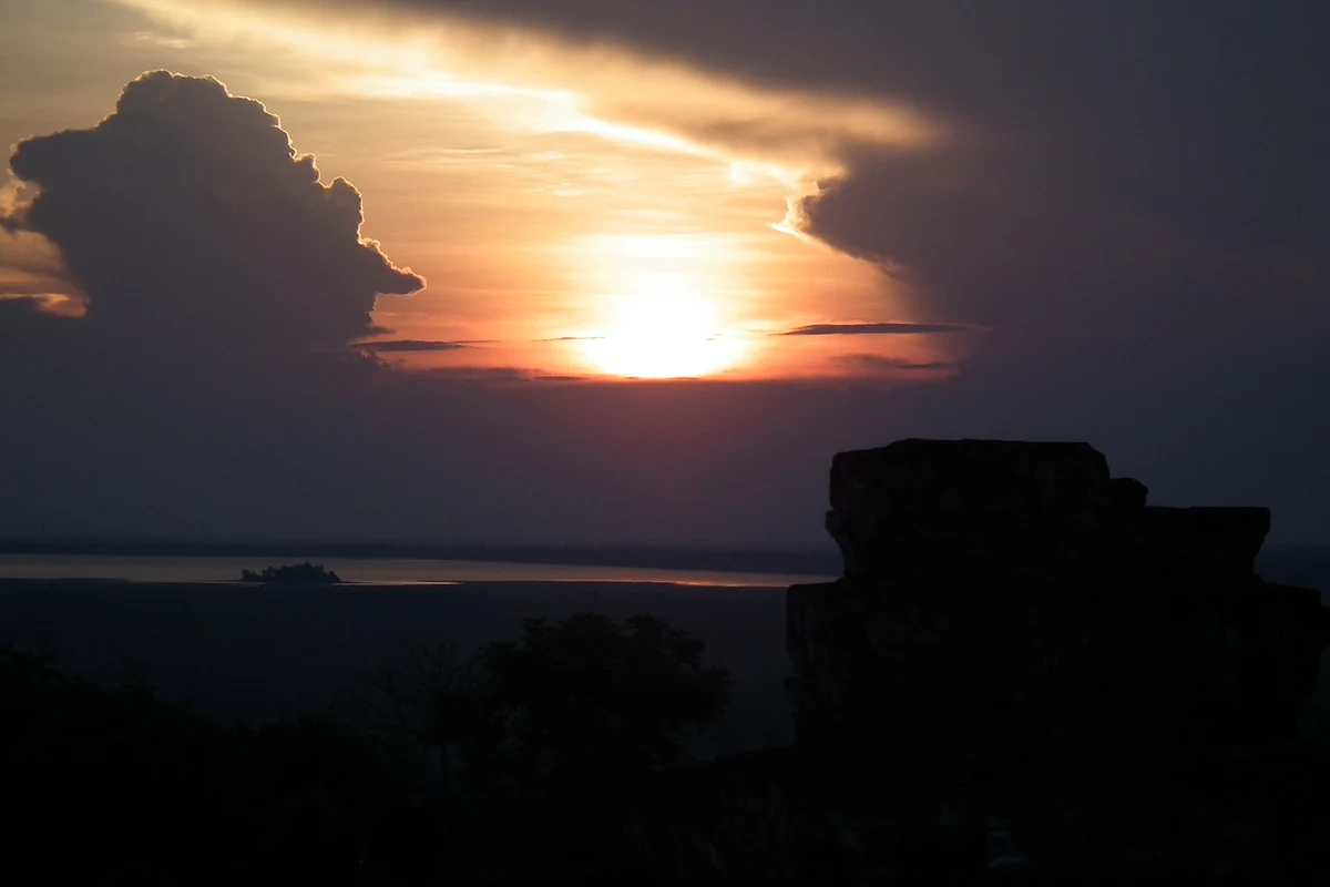 The sun setting over the horizon seen from Phnom Bakheng, seen on Angkor Wat tours from Siem Reap
