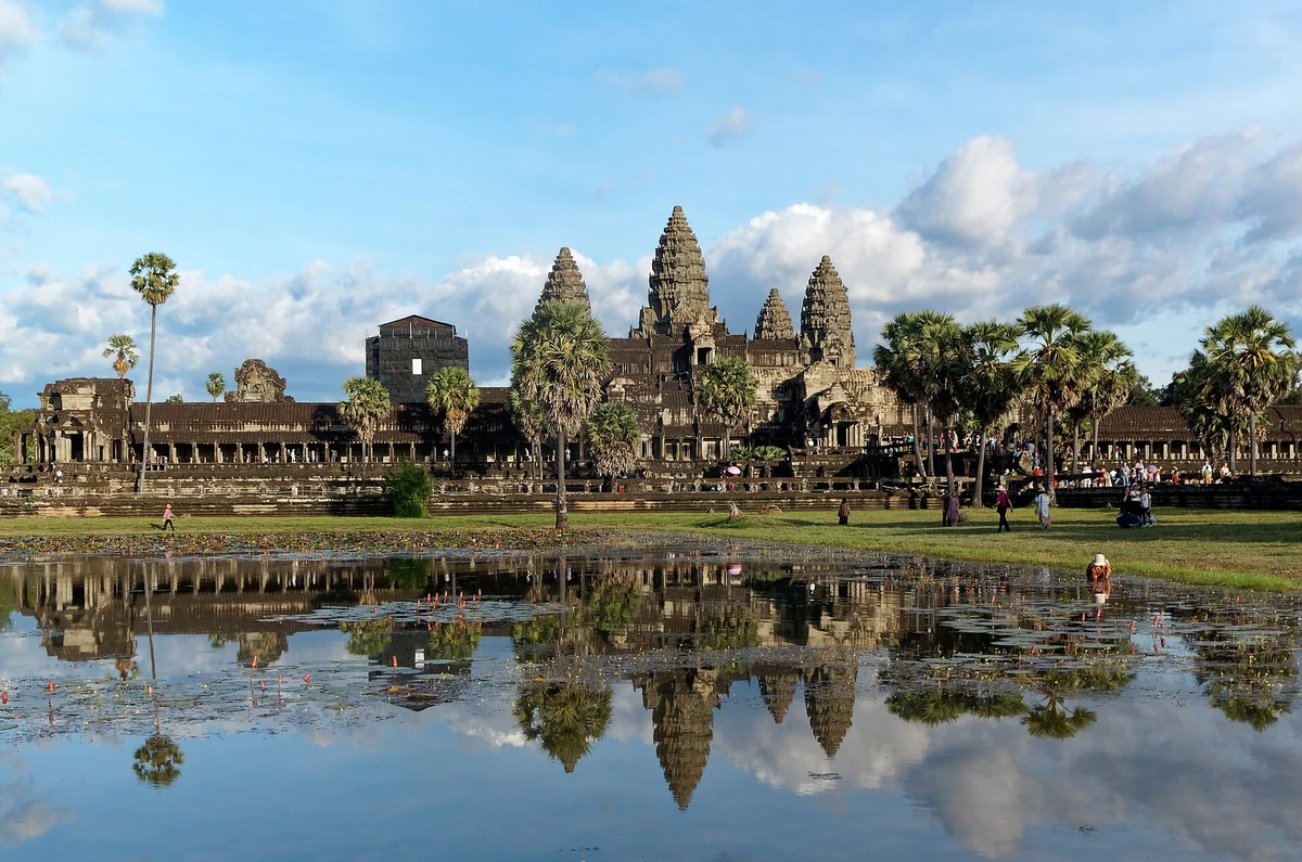 The central towers and west galleries of Angkor Wat reflected in the pond in daylight, the main temple on every Angkor Wat tour