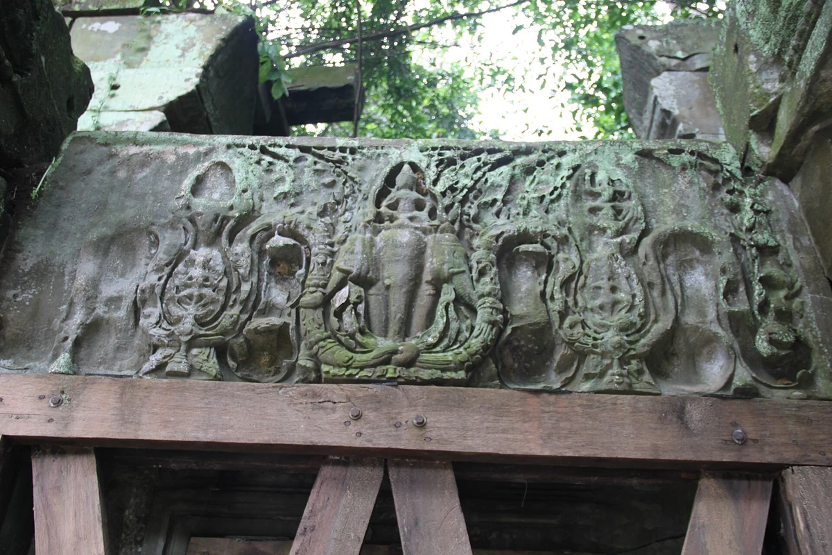 A carved lintel at Beng Mealea propped on a wooden support, seen on Angkor Wat tours from Siem Reap