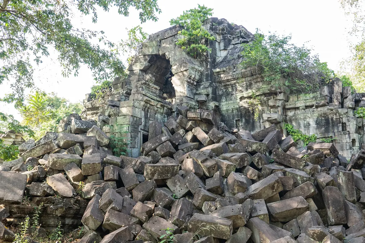Collapsed sandstone blocks and a ruined gallery overgrown with trees at Beng Mealea, the jungle temple on day trips beyond the main Angkor Wat tours